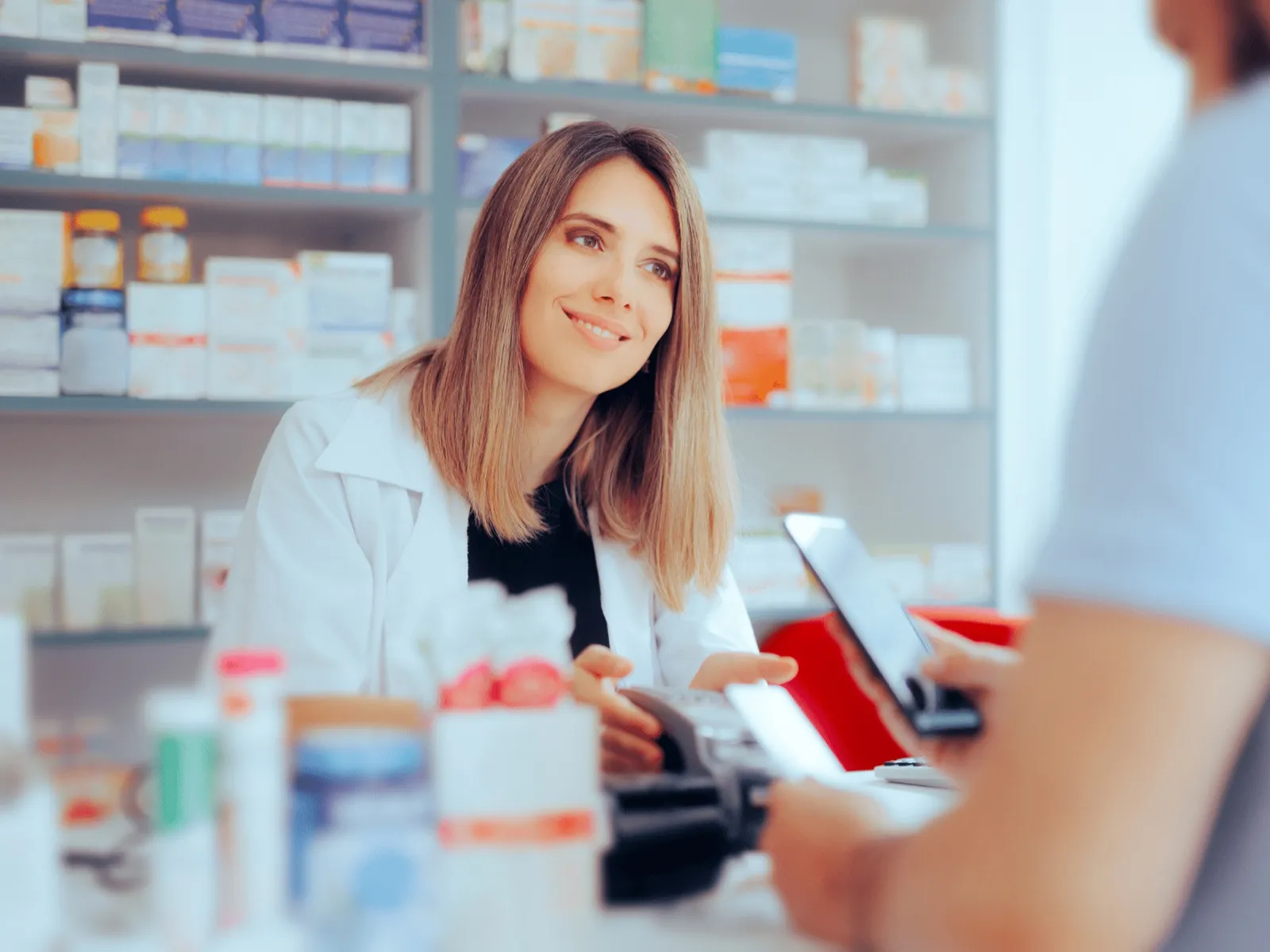 Pharmacist completing a prescription sale at an independent pharmacy counter