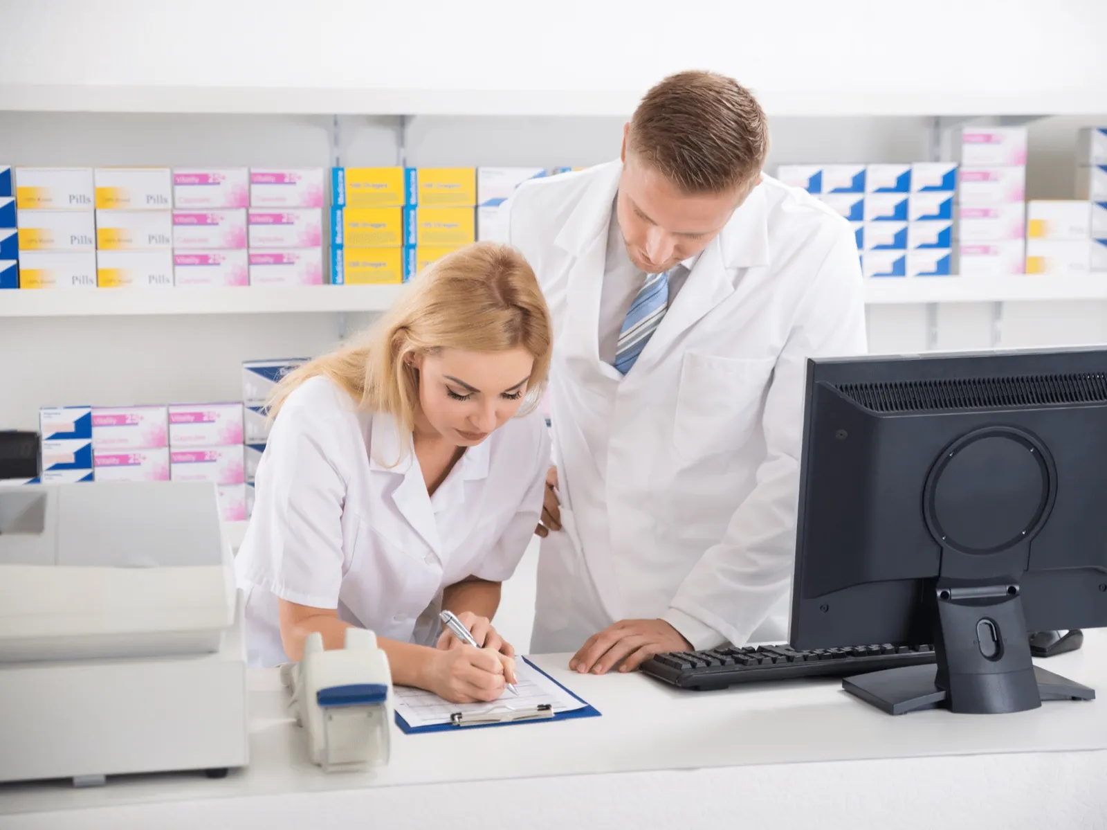 Two pharmacists reviewing claims on a pharmacy computer